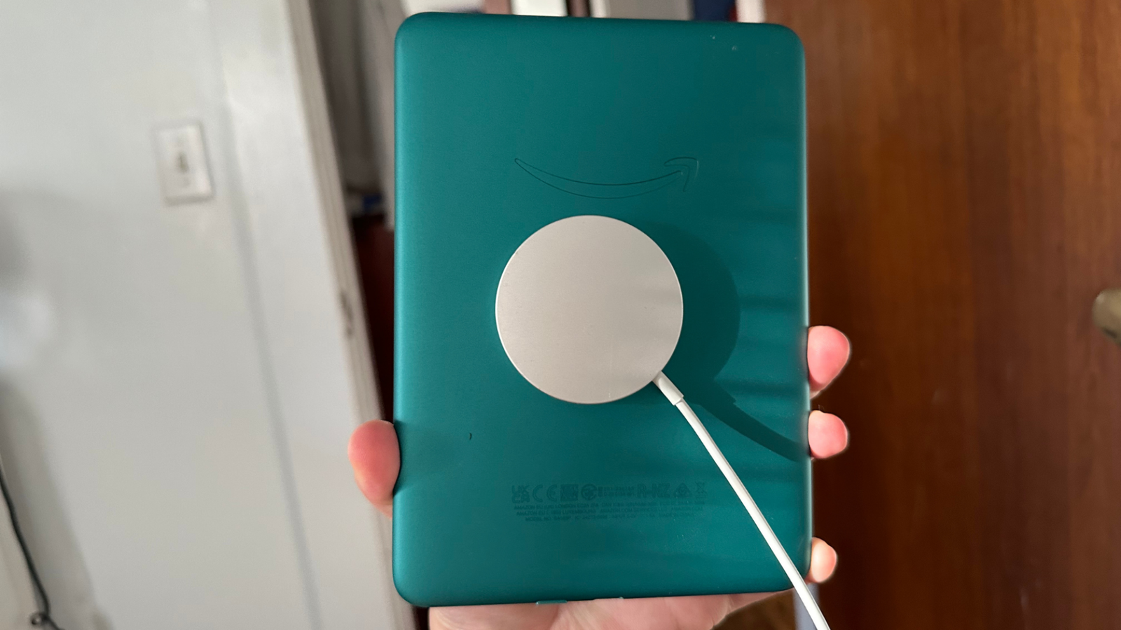 The Kindle Paperwhite Signature Edition with a Magsafe charger attached to it.