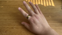 A hand wearing an Oura Ring 4 on its index finger.